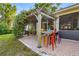 Charming backyard patio with a pergola, colorful seating, and lush landscaping at 5296 Slater Rd, Spring Hill, FL 34608