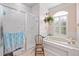 Well lit bathroom featuring a shower and a garden tub with a large window at 5296 Slater Rd, Spring Hill, FL 34608
