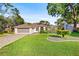 Charming home featuring a lush green lawn, complemented by mature trees and a two-car garage at 5296 Slater Rd, Spring Hill, FL 34608