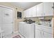 Bright laundry room with white cabinets, a sink, and modern washer and dryer units at 5296 Slater Rd, Spring Hill, FL 34608