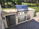 Outdoor kitchen featuring stainless steel grill, refrigerator, and convenient storage on a spacious deck at 5296 Slater Rd, Spring Hill, FL 34608