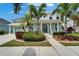 Inviting two-story home boasting lush landscaping, a welcoming front porch, and a light turquoise color at 5608 Skimmer Dr, Apollo Beach, FL 33572