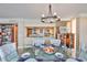 Elegant dining area with modern chandelier, seating for six, and views of the kitchen and living area at 5701 Mariner St # 701, Tampa, FL 33609