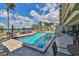 Resort-style pool with lounge chairs, tables and blue umbrellas under a bright blue sky with puffy white clouds at 5701 Mariner St # 701, Tampa, FL 33609