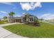 Charming single-story home with a well-manicured lawn, palm trees, and a two-car garage at 5924 Fieldmoor Ct, Palmetto, FL 34221
