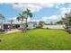 Expansive backyard with lush green lawn, patio, palm trees, and a white fence at 6010 Bayou Grande Ne Blvd, St Petersburg, FL 33703