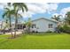 Well-maintained backyard features lush lawn, patio, and tropical landscaping with palm trees at 6010 Bayou Grande Ne Blvd, St Petersburg, FL 33703