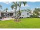 Large backyard with a lush lawn, patio area, and the back of the house at 6010 Bayou Grande Ne Blvd, St Petersburg, FL 33703