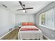 Cozy bedroom boasts wood floors, ceiling fan, and natural light from window at 6010 Bayou Grande Ne Blvd, St Petersburg, FL 33703
