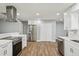Modern kitchen with stainless steel appliances, white cabinets and wood look tile floors at 6010 Bayou Grande Ne Blvd, St Petersburg, FL 33703