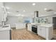 Modern kitchen featuring white cabinetry, marble countertops, stainless steel appliances, and hardwood floors at 6010 Bayou Grande Ne Blvd, St Petersburg, FL 33703