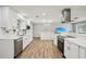 Modern kitchen featuring stainless appliances, white countertops and cabinets, and hardwood floors at 6010 Bayou Grande Ne Blvd, St Petersburg, FL 33703