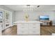 Kitchen island with white cabinets, marble countertops, and an elegant light fixture above at 6010 Bayou Grande Ne Blvd, St Petersburg, FL 33703