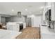 Kitchen with stainless steel appliances, white cabinets, quartz countertops and wood look tile floors at 6010 Bayou Grande Ne Blvd, St Petersburg, FL 33703