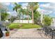 Back patio with grill and outdoor dining set, surrounded by tropical landscaping and a privacy fence at 6010 Bayou Grande Ne Blvd, St Petersburg, FL 33703