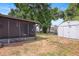View of the backyard featuring a screen enclosed patio and a storage shed at 6109 16Th St, Zephyrhills, FL 33542