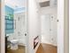 Bright hallway view showcasing bathroom with shower/tub combo, toilet, and black metal shelving for storage at 6109 16Th St, Zephyrhills, FL 33542