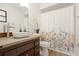 Bathroom featuring a floral shower curtain, vanity, and modern sink and faucet, creating a spa-like experience at 6109 16Th St, Zephyrhills, FL 33542