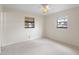 Inviting bedroom with neutral carpet, a ceiling fan, and two windows, creating a peaceful retreat at 6109 16Th St, Zephyrhills, FL 33542