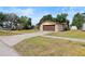 Detached single-car garage with brown door, beige stucco siding, and stone accents at 6109 16Th St, Zephyrhills, FL 33542