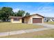 Charming single-story home featuring a stone-accented facade, lush landscaping, and an attached garage at 6109 16Th St, Zephyrhills, FL 33542