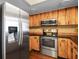 Kitchen with stainless steel appliances, wood cabinets, black countertops, and tiled backsplash at 6109 16Th St, Zephyrhills, FL 33542