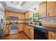 Cozy kitchen featuring wood cabinets, modern appliances, dark countertops, and a stainless steel sink at 6109 16Th St, Zephyrhills, FL 33542