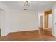 Spacious living room with hardwood floors, neutral walls, and recessed lighting, adjacent to entry and hallway at 6109 16Th St, Zephyrhills, FL 33542
