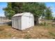 Outdoor metal shed with hinged door in a fenced backyard at 6109 16Th St, Zephyrhills, FL 33542