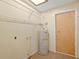 Utility room featuring a water heater, overhead light, and storage shelving at 6109 16Th St, Zephyrhills, FL 33542