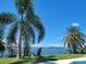 Backyard showcasing mature palm trees, waterfront views, and dock access for relaxation and enjoyment at 7092 S Shore S Dr, St Petersburg, FL 33707