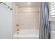Bathroom featuring a tub with white tile and updated bronze fixtures at 7092 S Shore S Dr, St Petersburg, FL 33707