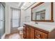 Bathroom with wood-look tile, wood vanity, and a large mirror at 7092 S Shore S Dr, St Petersburg, FL 33707