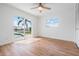 Bright bedroom featuring wood floors, ceiling fan, and sliding doors to the outdoor pool at 7092 S Shore S Dr, St Petersburg, FL 33707