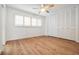 Bright bedroom features wood floors, ceiling fan, plantation shutters, and ample closet space at 7092 S Shore S Dr, St Petersburg, FL 33707