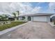 Charming home exterior with a well-manicured lawn, beautiful landscaping, and a driveway at 7092 S Shore S Dr, St Petersburg, FL 33707