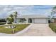 Charming home exterior with a well-manicured lawn, beautiful landscaping, and a driveway at 7092 S Shore S Dr, St Petersburg, FL 33707