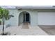 Inviting front entrance with stucco archway, stylish door, and well-manicured landscaping at 7092 S Shore S Dr, St Petersburg, FL 33707