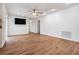 Open living room with wooden floors, modern lighting, and easy access to other areas of the house at 7092 S Shore S Dr, St Petersburg, FL 33707