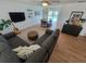 Comfortable living room featuring a gray sofa, wooden floors, modern decor, and direct access to the pool at 7092 S Shore S Dr, St Petersburg, FL 33707