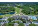 Aerial view showcasing the community clubhouse, pool, and golf course amidst lush greenery at 7253 Cleopatra Dr, Land O Lakes, FL 34637