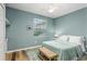 Cozy bedroom with wood floors, natural light, and soft green walls at 7253 Cleopatra Dr, Land O Lakes, FL 34637