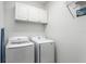 Functional laundry room with washer, dryer, and overhead storage cabinets at 7253 Cleopatra Dr, Land O Lakes, FL 34637