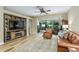 Elegant living room boasts built-in entertainment center, wood floors, and sliding glass doors to the lanai at 7253 Cleopatra Dr, Land O Lakes, FL 34637