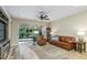 Open living area with a cozy leather sofa, large windows, and hardwood floors at 7253 Cleopatra Dr, Land O Lakes, FL 34637