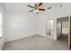 Bright bedroom featuring a ceiling fan, neutral carpet, and attached bathroom at 8612 Hunters Key Cir, Tampa, FL 33647