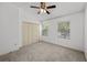 Bedroom featuring neutral carpet, ceiling fan, and view of outdoor landscaping from the windows at 8612 Hunters Key Cir, Tampa, FL 33647