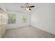 Carpeted bedroom with ceiling fan, two windows and closet at 8612 Hunters Key Cir, Tampa, FL 33647