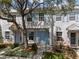 Charming townhouse featuring light blue shutters, complemented by lush greenery and a mature tree at 8612 Hunters Key Cir, Tampa, FL 33647