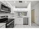 Bright kitchen featuring stainless steel appliances, white cabinets, countertops and tiled flooring at 8612 Hunters Key Cir, Tampa, FL 33647